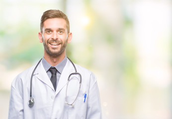 Young handsome doctor man over isolated background with a happy and cool smile on face. Lucky person.