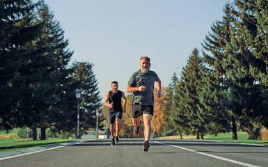 The old and young sportsmen running on the road