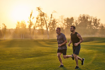 Obraz premium The happy sportsmen running in the beautiful park