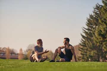 The father and son sitting on the grass and talking