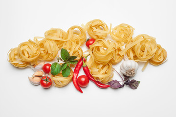 Pasta Spaghetti with ingredients for cooking pasta on a white background, top view.