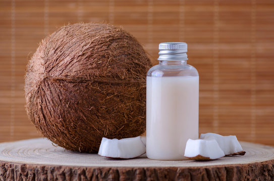 diy cosmetic bottle and fresh organic coconut , natural background