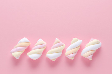 marshmallow in pastel colors on pink background with copy space