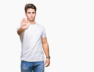 Young handsome man wearing white t-shirt over isolated background doing stop sing with palm of the hand. Warning expression with negative and serious gesture on the face.