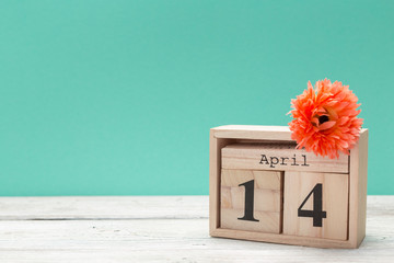 April 14th. Day 14 of april month, calendar on table with blue  background. Spring time