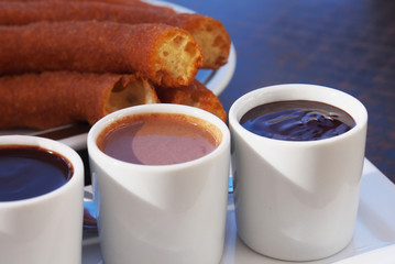 Typical Spanish snack churros are deep-fried pastries and served with hot chocolate everywhere in...