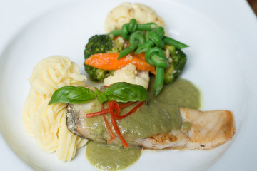Fresh fillet of sea bass pan fried in lemon caper sauce served with mashed potatoes and green vegetables