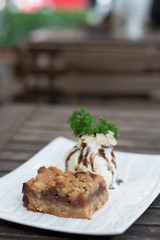 Granny Smith apples crumble pie with cinnamon and spices, and a scoop of vanilla ice cream.