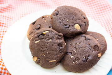 Chocolate cookies on orange fabric top view close up