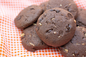Chocolate cookies on orange fabric top view close up