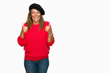 Middle age adult woman wearing fashion beret over isolated background success sign doing positive gesture with hand, thumbs up smiling and happy. Looking at the camera with cheerful expression