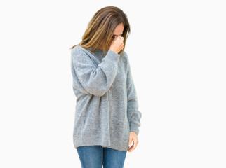 Beautiful middle age woman wearing winter sweater over isolated background tired rubbing nose and eyes feeling fatigue and headache. Stress and frustration concept.