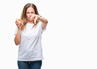Middle age hispanic woman eating pizza slice over isolated background with angry face, negative...