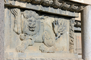 lion sculptures in grey wall