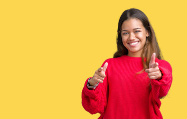 Young beautiful brunette woman wearing red winter sweater over isolated background pointing fingers to camera with happy and funny face. Good energy and vibes.
