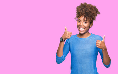 Beautiful young african american woman over isolated background success sign doing positive gesture...