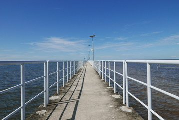 Obraz premium Perspective view of jetty with LED street light with solar cell on clear blue sky.