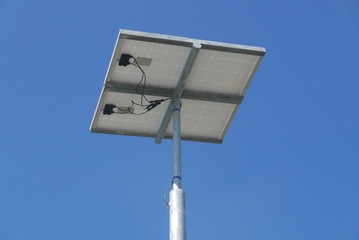 Close up view of LED street light with solar cell on clear blue sky background with clouds.