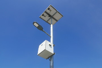 Close up view of LED street light with solar cell on clear blue sky background with clouds.