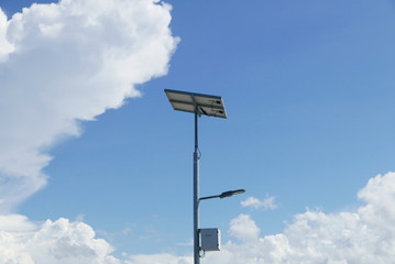 Close up view of LED street light with solar cell on clear blue sky background with clouds.