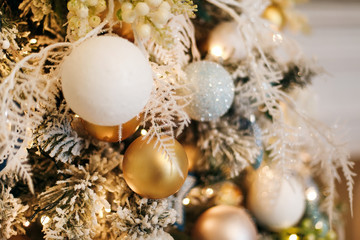  Close-photographed Christmas decorations on a gold and white Christmas tree with sparkles. Christmas decor elements