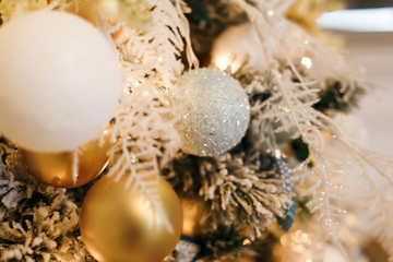  Close-photographed Christmas decorations on a gold and white Christmas tree with sparkles. Christmas decor elements