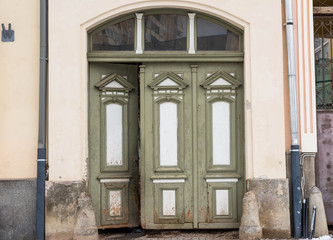 Fototapeta premium Opened , green hand carved wooden entrance on a residentual house .