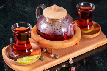 traditional turkish tea cup, tea ceremony, Cup of freshly brewed black tea, warm soft light, darker marble background