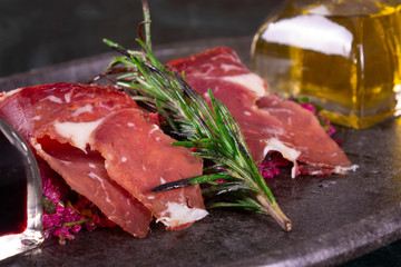 Soy sauce and olive oil with raw turkish bacon rashers on marble background