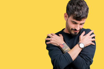 Young handsome man over isolated background Hugging oneself happy and positive, smiling confident....