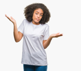 Young afro american woman over isolated background clueless and confused expression with arms and hands raised. Doubt concept.