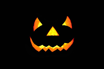 Glowing scary face made of pumpkin on black background. Halloween