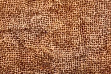 Brown crumpled burlap texture background. Macro of hessian cloth