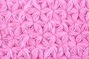 Pink woolen texture background. Macro of knitted cloth