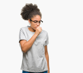 Young afro american woman wearing glasses over isolated background feeling unwell and coughing as...