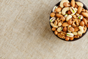 Roasted peanuts in the shell and peeled in a cup, against a gray wooden table