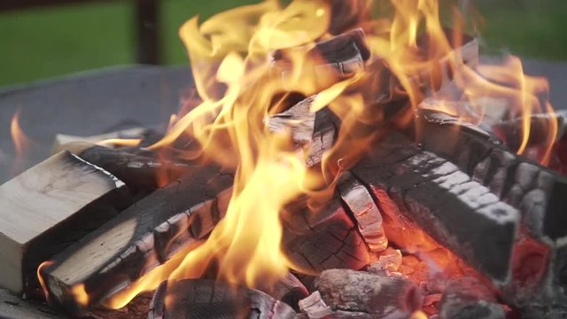 Fire wood burning on a metal fire pit slow motion