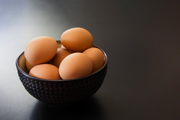 A bowl filled with brown organic eggs on the kitchen counter