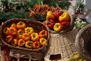 red green yellow orange bell peppers and baskets at a market