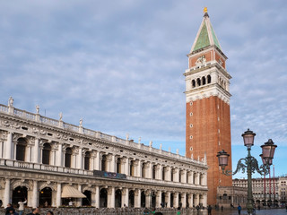 Fototapeta na wymiar VENICE, ITALY, NOV 1st 2018: Saint Mark's or San Marco Square or Piazza and Bell or observation tower with classic vintage italian street lanterns. Beautiful perspective vertical view. Day, Summer.