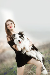 portrait of cool girl hold on hands dog border collie in windy field