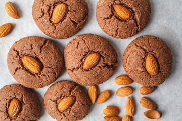 Chocolate cookies with almonds on white background, top view. Vegan dessert concept.