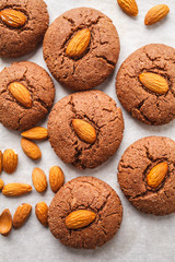 Chocolate cookies with almonds on white background, top view. Vegan dessert concept.