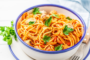 Pasta with turkey meatballs and tomato sauce in white dish.