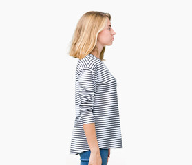 Beautiful young woman wearing stripes sweater over isolated background looking to side, relax profile pose with natural face with confident smile.