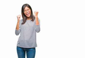 Obraz na płótnie Canvas Young asian woman wearing glasses over isolated background very happy and excited doing winner gesture with arms raised, smiling and screaming for success. Celebration concept.
