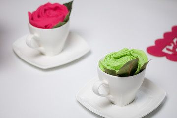 Preparation of floral decorations using napkins and table forks. The finished flower is placed in a cup and decorated with green leaves.