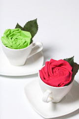 Preparation of floral decorations using napkins and table forks. The finished flower is placed in a cup and decorated with green leaves.