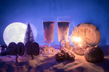 Two glasses of champagne with Christmas decoration. Traditional winter holiday alcohol drink in snow with creative New Year artwork. Copy space.