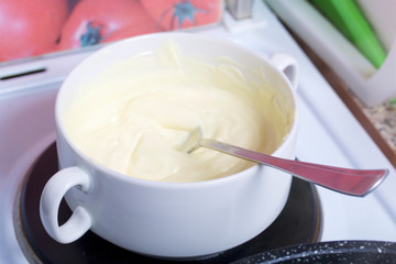 Melted white k chocolate in white cups. Stand for making dessert.